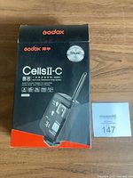 Retail box front showing Godox Cells II-C branding and image of transceiver