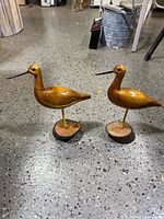 Both wooden shorebird sculptures on bases