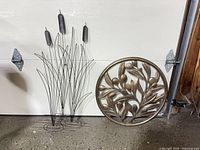 Full view of both metal wall art pieces against garage door