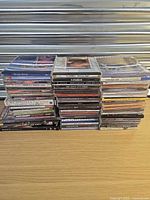 Two stacks of assorted audio CDs on tabletop