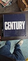 Front cover of Century book with marker for scale