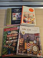 Top view of four craft books: two French hardcovers on sewing and decoration, two English softcovers on quilting