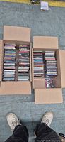 Two cartons filled with stacked music CDs