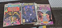 Close view of three stacks of Star Trek comics showing top issue of each stack