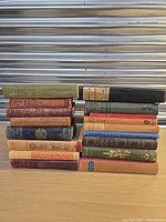 Two stacks of fifteen vintage hardcovers showing varied spine colours and decorative designs