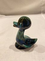 Right side view of ceramic duck figurine showing glossy drip glaze