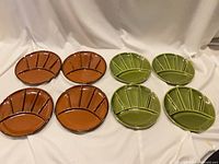 Eight divided plates laid out, four brown four green