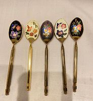 Front view of five cloisonné spoons showing enamel designs
