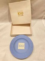 Plate resting in open box showing Eaton centennial logo inside lid