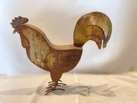 Full left profile of metal rooster showing patina and overall stance