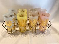 Front view of eight frosted tumblers in metal caddy showing colors and pattern