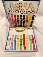 Open box showing watch, 19 straps, 18 bezels