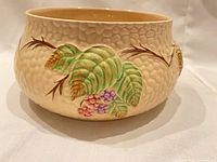 Side view showing dimpled exterior and hand-painted blackberry motif