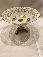 Side view of bowl on ornate metal pedestal