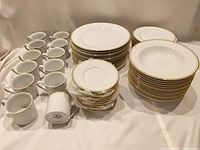 Group view of entire 60-piece dinnerware set showing stacks of plates, bowls, cups and saucers