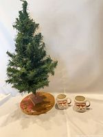 Artificial tree with two Santa mugs