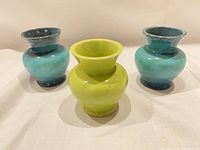 Front view of three small ceramic vases