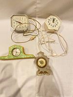 Front view of four assorted clocks