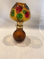 Full view of amber glass oil lamp with cabochon shade