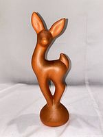 Front view of matte orange ceramic stylized deer figurine