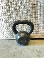 Front view of dark gray 25 lb cast iron kettlebell