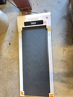 Full view of walking pad treadmill showing frame, belt and warning decals