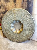 Front view showing ornate engraving and scalloped center