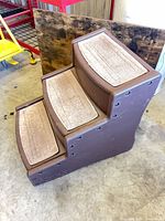 Overall view of brown three-step pet stairs showing carpet treads and side profile