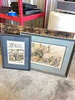 Both framed prints leaning against shelving