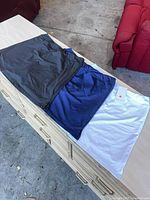 Three Ekouaer skorts laid flat showing colors black, navy, white