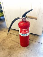 Front view showing red cylinder, instruction label, hose attached