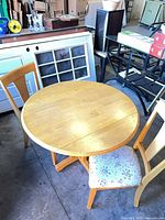 Round light honey wood table with two matching chairs