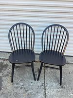 Front view of both black Windsor spindle-back chairs