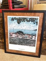 Full view of framed print leaning against wall