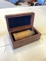 Monocular inside open wooden box