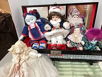 Group shot of dolls arranged in front of and inside wood display case