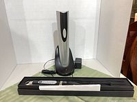 Oster wine opener on charger with AC adapter beside Brink electronic cooking fork in box