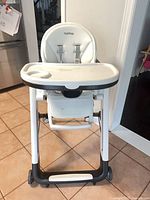 Front view of Peg Perego high chair showing tray, seat, frame, wheels