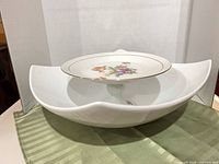 Both porcelain pieces together: serving bowl holding pedestal compote