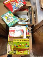 Stack of boxed kits showing papier-mache, Whirl-O-Paint, Astrolite, Show Magic, Hot Wheels speedometer, Fuzzy-Felt