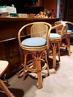 Three rattan swivel bar stools at counter