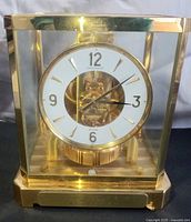 Front view of Jaeger LeCoultre Atmos clock showing dial, glass case and base plaque
