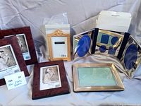 Overview of six new photo frames including three Windsor wood frames, boxed Melannco frame, gold arch-top frame, silver-plated folding and single frame