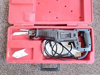 Open case showing saw, cord, blade, manual