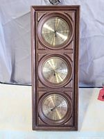 Front view of Springfield weather station showing three brass-tone gauges in faux wood frame