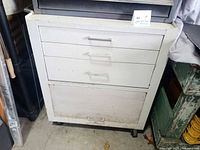 Front view showing three drawers, lower compartment and casters