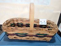 Side view of wicker basket showing handle and colored weave pattern