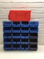 Stack of 20 small blue/black bins with red large bin on top