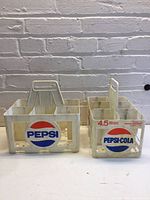 Front view of both plastic Pepsi carriers side by side showing logos