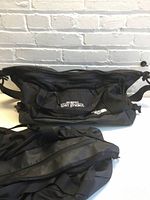 Front view of one duffel showing logos and top zip opening